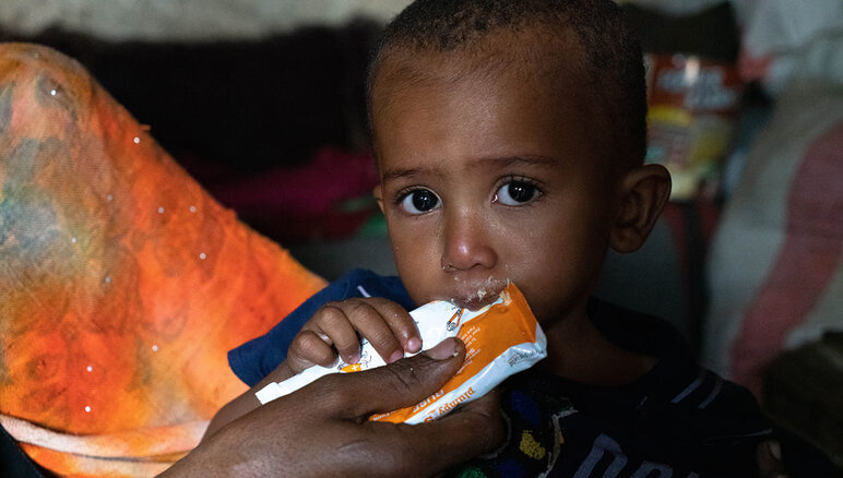 Yémen. La mère de Sultan lui donne une pate d'arachide nutritive à la maison. Il souffre de malnutrition aigu? modérée. Grace à l'alimentation complémentaire qu'il re?oit du PAM, Sultan a commencé à prendre du poids et a plus d'énergie qu'avant. Mais il a encore besoin d'un traitement. Sa famille re?oit également une aide alimentaire du PAM : farine, haricots secs, huile, sucre et sel. PAM/Mohammed Awadh